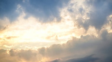 Sabahın erken saatlerinde, tüylü bulutların arasından süzülen altın ışıkla canlı bir gündoğumu serin ve güzel bir gökyüzü yaratıyor. Sahne, doğanın güzelliğini şafakta yakalar..