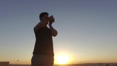 Erkek fotoğrafçı fotoğraf günbatımı binasında üstüne çekmek