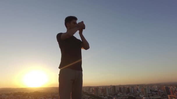 Mužské Fotograf Fotí Vrcholu Budovy Při Západu Slunce — Stock video