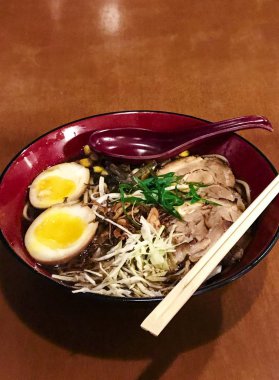 Ahşap arka plan üzerinde kırmızı kupa geleneksel Japon domuz Lam (harf). 