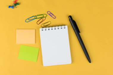 renkli işaretleri, etiket ve sarı zemin üzerine clipers gibi op görünümü boş defter ve okul malzemeleri.