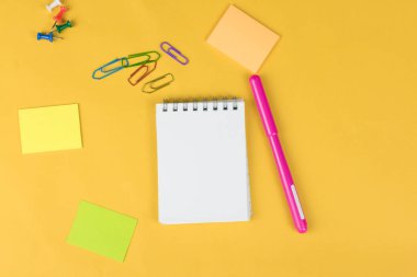 renkli işaretleri, etiket ve sarı zemin üzerine clipers gibi op görünümü boş defter ve okul malzemeleri.