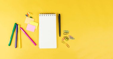 Renkli işaretleri, etiket ve sarı zemin üzerine clipers gibi en iyi görünümü boş defter ve okul malzemeleri. 