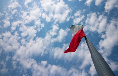 Meksika bayrağı bir bulut gökyüzünde çırpınan.