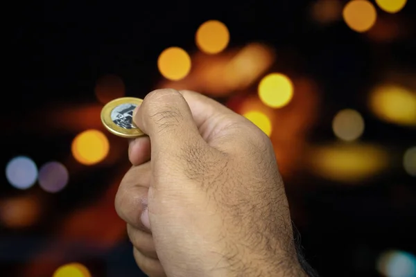 Holding a Brazilian money coin at a blurry background — Stock Photo, Image