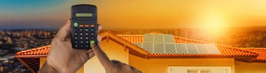 Bir güneş paneli fotovoltaik kurulum bir hesap makinesi tutma 