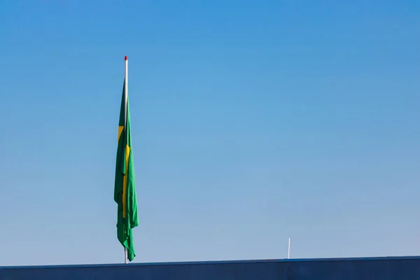 Brasilianische Flagge auf Mast ohne Wind vor blauem Himmel. — Stockfoto