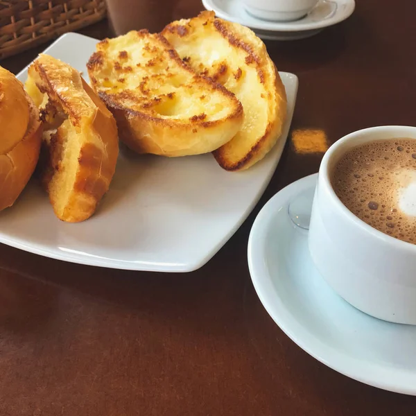 Brasiliansk frukost. Capuccino Cup och rostat bröd med smör — Stockfoto
