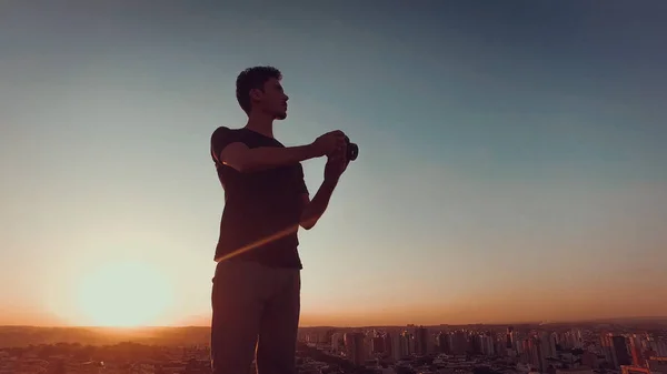 Photographe sur le toit du bâtiment au coucher du soleil — Photo