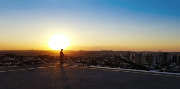 Bir Binanın Tepesinde Gözlüklü Bir Adamın Silueti — Stok fotoğraf