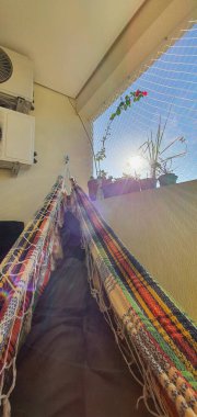 Gün doğumunda hamakta dinlenen bacaklar.