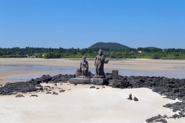 Jeju Adası, Güney Kore, Pyoseon Haevich Beach, 9 Eylül 2015: iki Haenyeo - Pyoseon Haevich Sahilde güneşli Jeju Adası'nın kadın dalgıçlar adamış heykelleri