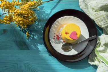 kalp ve şube mimoza çiçek ahşap arka plan mavi sarı mini kek üstten görünüm