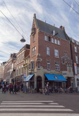 Lahey, Hollanda, 14 Ekim 2018: Tipik Lahey Caddesi'nde eski tuğla ile akşam ev sahipliği yapmaktadır. insanlar yürürken, insanlar ve kafeler