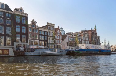 Amsterdam, Hollanda, 10 Ekim 2018: Tuğla ile Amstel Nehri görünümünden Cityscape cepheler ve mavnalar graffiti ile kaplarda evler
