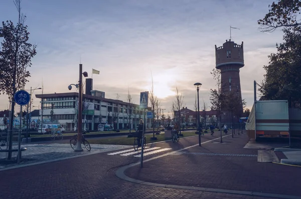 Vista del ciudadano de Den Helder montar en bicicleta por la noche con la torre de agua — Foto de Stock