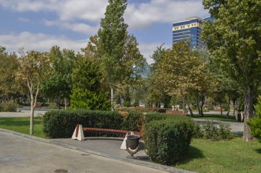 Bakü Bulvar'daki çalıların içine yerleştirilen bank ve çöp tenekesi