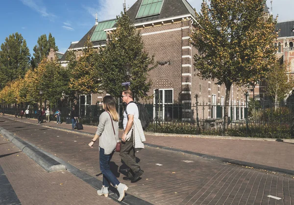Koppel wandelen in de buurt van Rijksmuseum muren op zonnige dag — Stockfoto
