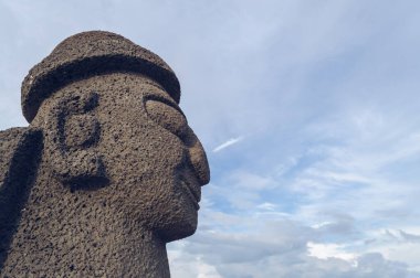 Bulutlu gökyüzüne karşı Geumneung sahilindeki Dol Hareubang profili