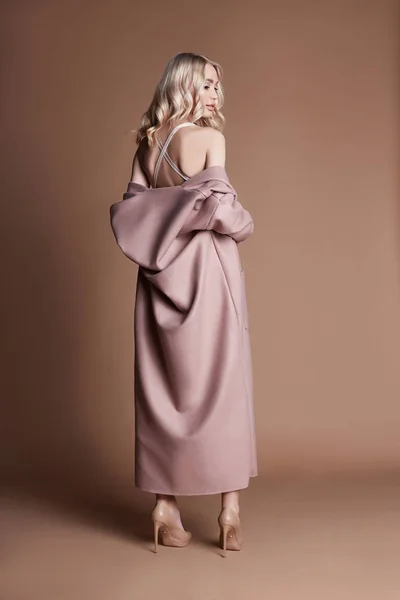 Belle Femme Blonde Posant Manteau Rose Sur Fond Beige Vêtements — Photo