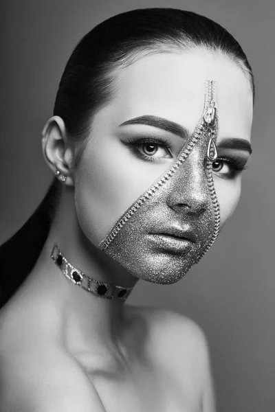 Creative gloomy face makeup girl. Zipper of clothes on skin. Creative fashion beauty cosmetics and skin care Halloween. Brunette on dark background, beautiful big eyes and smooth skin. Black and white