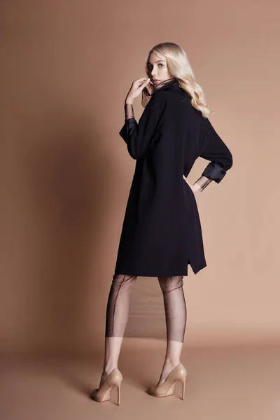 Mulher Loira Bonita Posando Casaco Preto Com Saco Fundo Bege — Fotografia de Stock