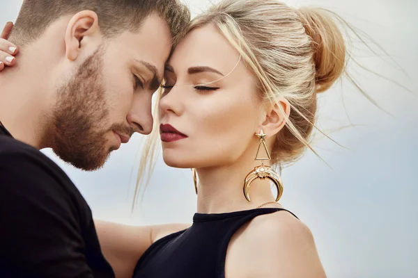Kapadokya'nın dağlarında Doğu çift aşık hugs ve öper. Aşk ve sevgi dolu duygular Türkiye'de tatil çift. Portre portre erkek ve kadın. Güzel Crescent moon küpe kız kulakları üzerinde