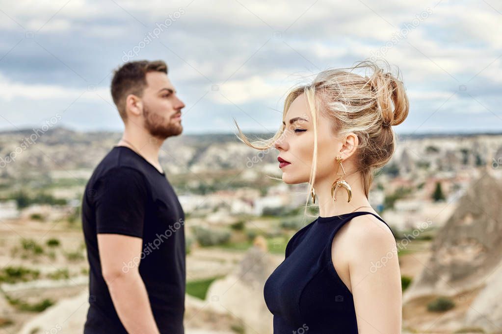 In love Eastern couple in mountains of Cappadocia hugs and kisses. Love and emotions loving couple vacationing in Turkey. Closeup portrait man and woman. Beautiful Crescent moon earrings on girl ears