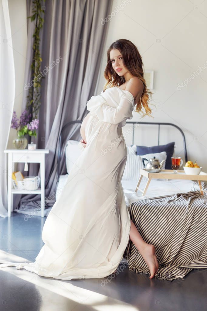 Fashion portrait pregnant woman blonde, perfect figure of girl. Woman is waiting for the birth of a baby. Art woman in late pregnancy. Motherhood and baby. Future mother in beautiful clothes