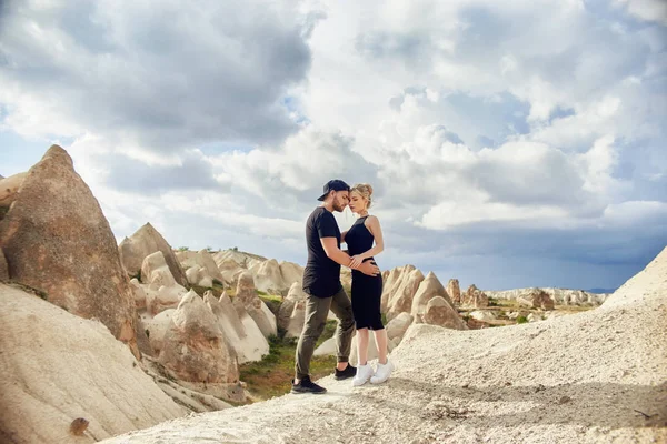 Love and emotions loving couple resting in Turkey. In love Eastern couple in the mountains of Cappadocia hugs and kisses. Close-up portrait of a man and woman. Beautiful Crescent earrings on girl ears