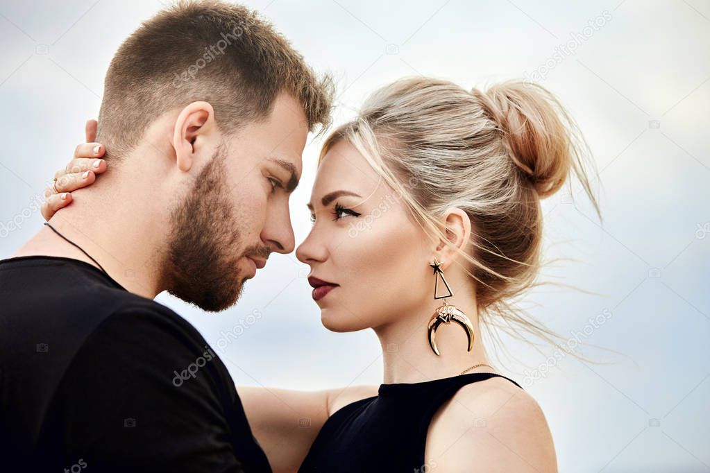 Love and emotions loving couple resting in Turkey. In love Eastern couple in the mountains of Cappadocia hugs and kisses. Close-up portrait of a man and woman. Beautiful Crescent earrings on girl ears