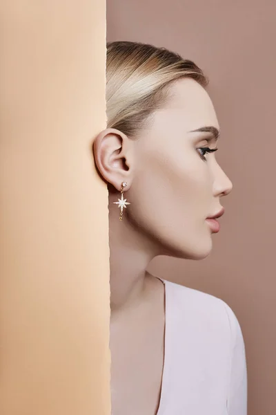 Earrings and jewelry in ear of a sexy blonde woman pressed again