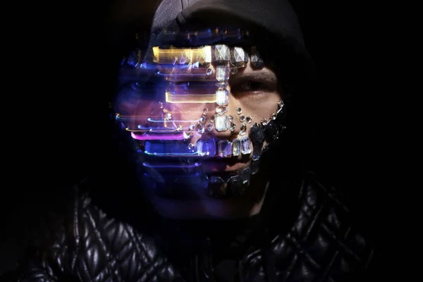 Art portrait of a hooded man with big rhinestones on his face. M