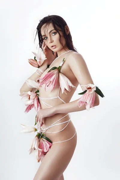 Beautiful naked woman girl tied with ropes and Lily flowers. Art
