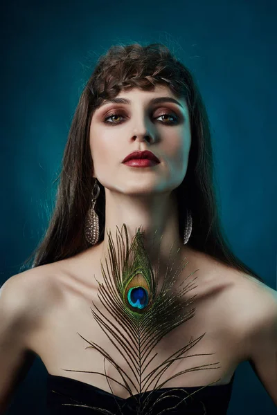 Eastern Arab woman with a peacock feather in her hands near her — Stock Photo, Image