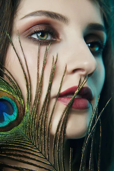 Eastern Arab woman with a peacock feather in her hands near her