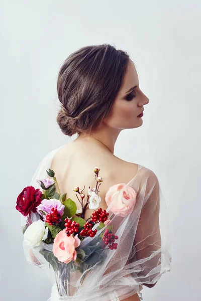 Mulher com um buquê de flores artificiais atrás dela. A menina — Fotografia de Stock