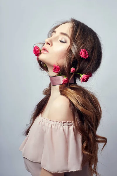 Beautiful woman with rose flowers in her long hair, a bandage ar — Stock Photo, Image