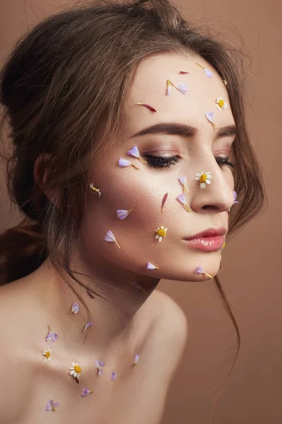 Pétalas de flores no rosto menina, cosméticos mulher para hidratar rosto s — Fotografia de Stock