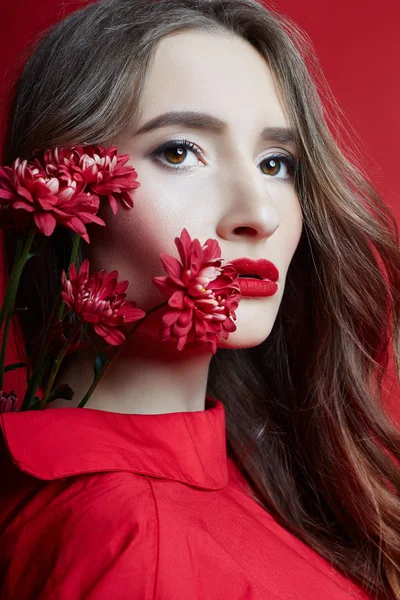 Mulher com cabelo encaracolado em vestido vermelho e mão flor — Fotografia de Stock