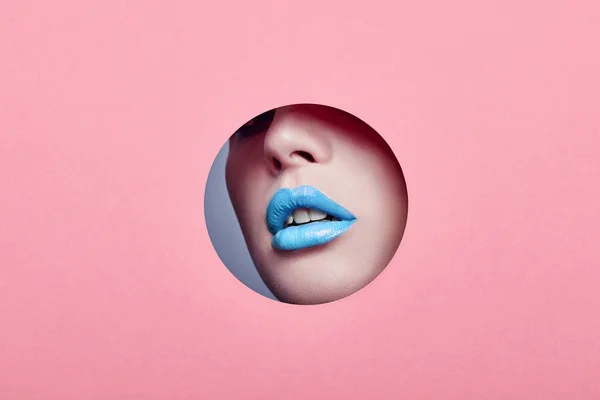 Advertising Beautiful plump lips bright blue color, woman looks