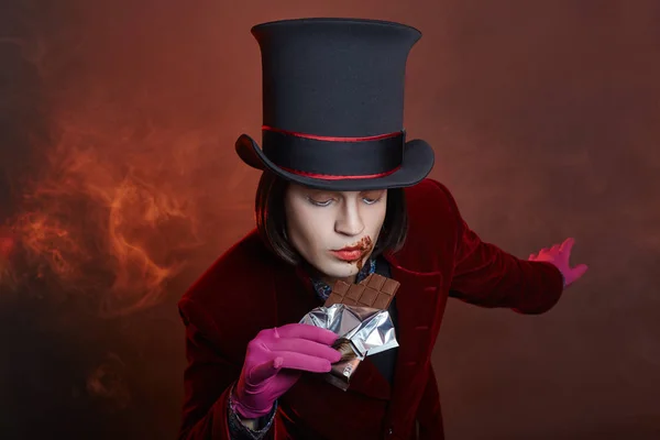 Fabulous circus man in a hat and a red suit posing in the smoke — Stock Photo, Image