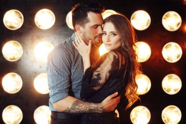 Sevgi dolu çift parlak ışıklarkarşı kanepede sarılma 