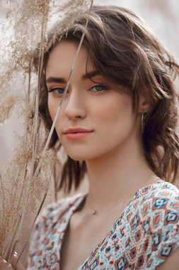 Sonbaharda uzun otlu bir tarlada güzel kız. Sanat portrai