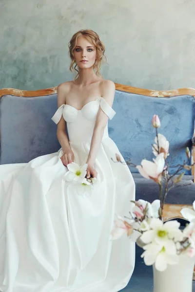 Kanepede yatan şık uzun elbiseli gelin. Beyaz weddin
