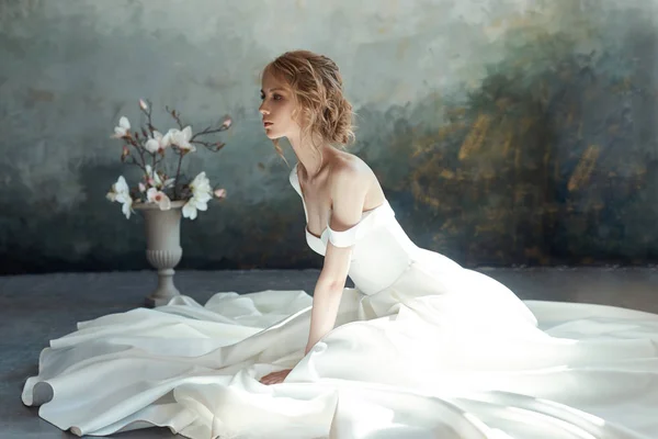 Menina em um vestido longo chique sentado no chão. Casamento branco dr — Fotografia de Stock