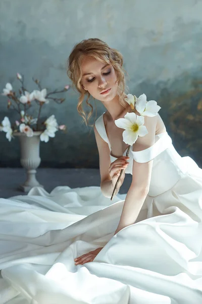 Chica en un vestido largo elegante sentado en el suelo. Boda blanca dr — Foto de Stock