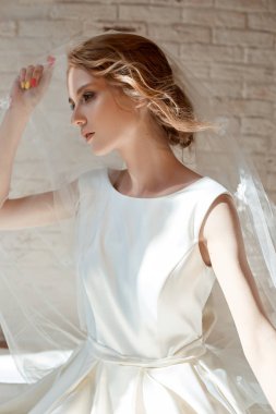 Uzun beyaz dres akşam güneşinde güzel ince sarışın