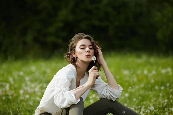 Arasında bahar çim üzerinde bir alanda oturan bir kız portresi — Stok fotoğraf