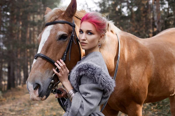 Vrouw op een paard in de herfst. Creatief helder roze make-up op de — Stockfoto